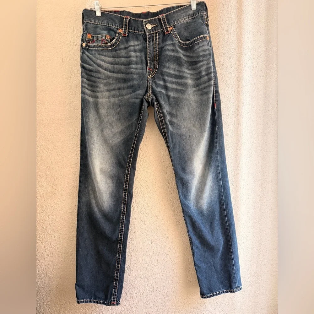 True Religion jeans feature a dark wash and bold signature stitching. Skinny